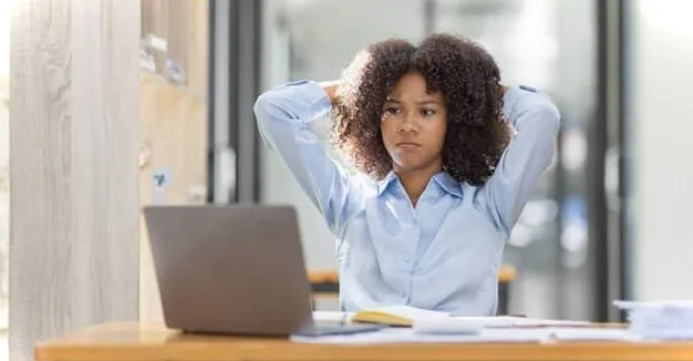 Mujer mirando su computadora portátil leyendo cómo encontrar celdas combinadas en Excel